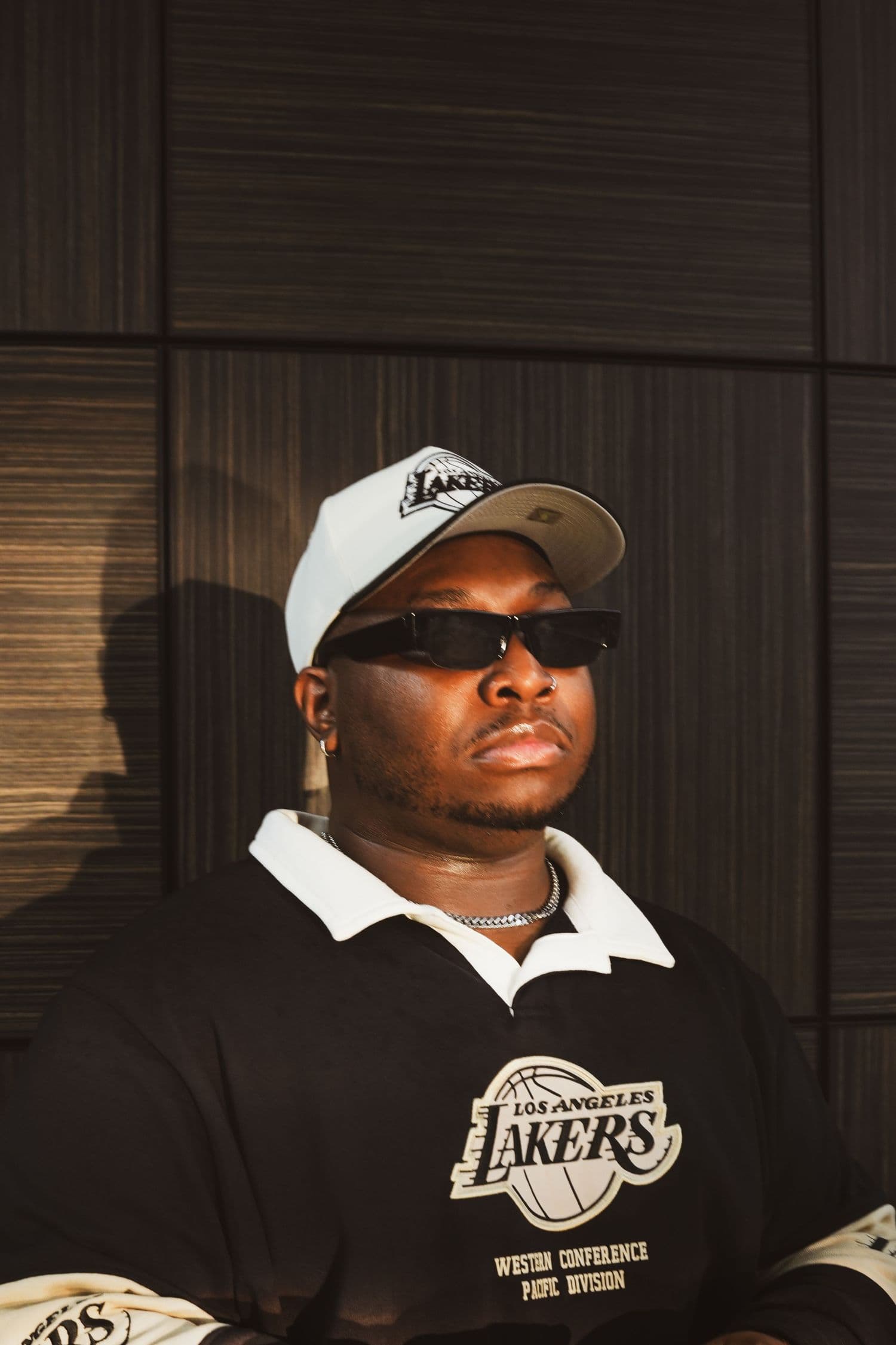 Low-angle portrait in a white cap, dark sunglasses and a Lakers jersey