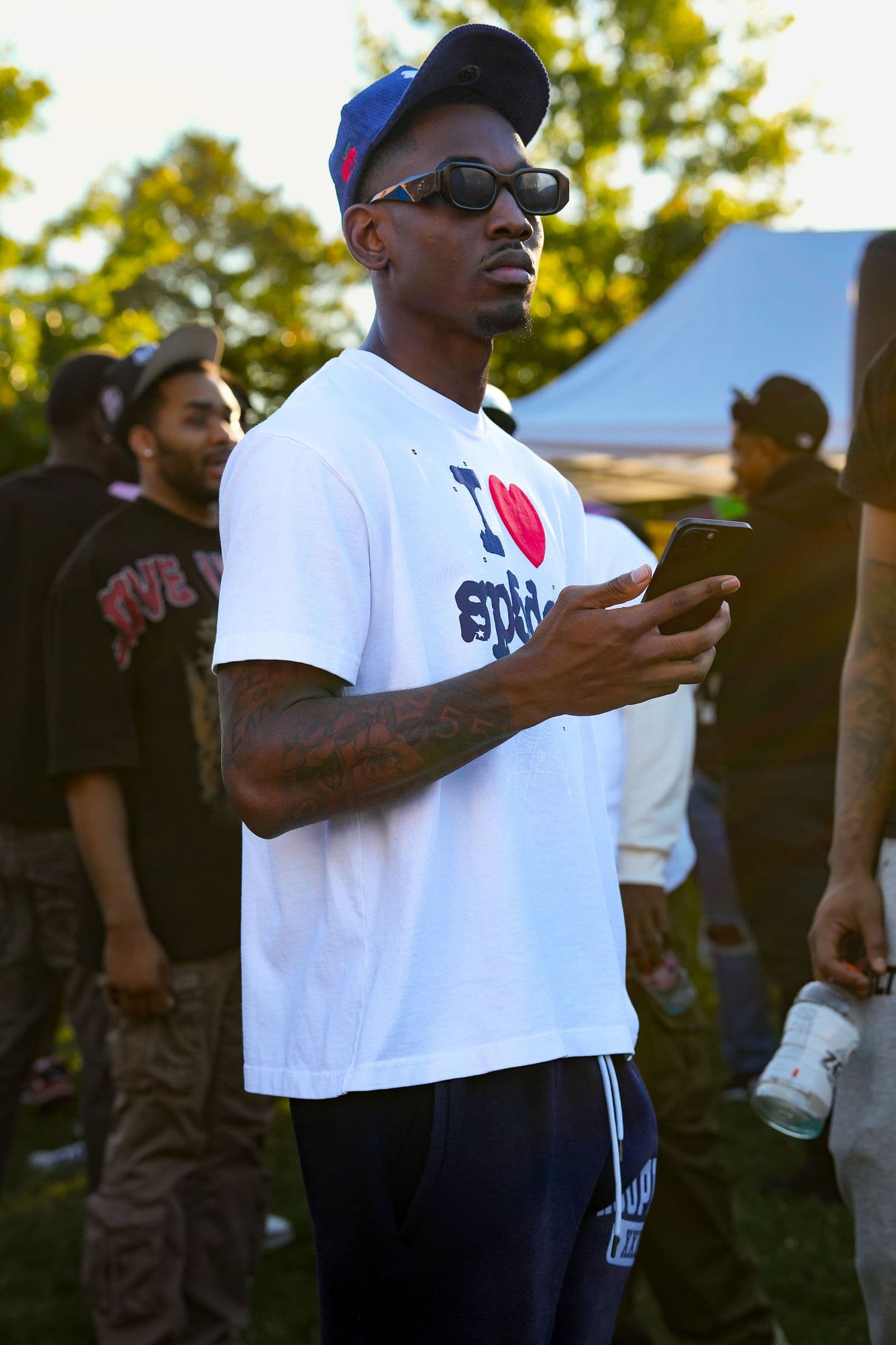 Outdoor community event: sunglasses, a blue cap and an I love NY tee in the crowd